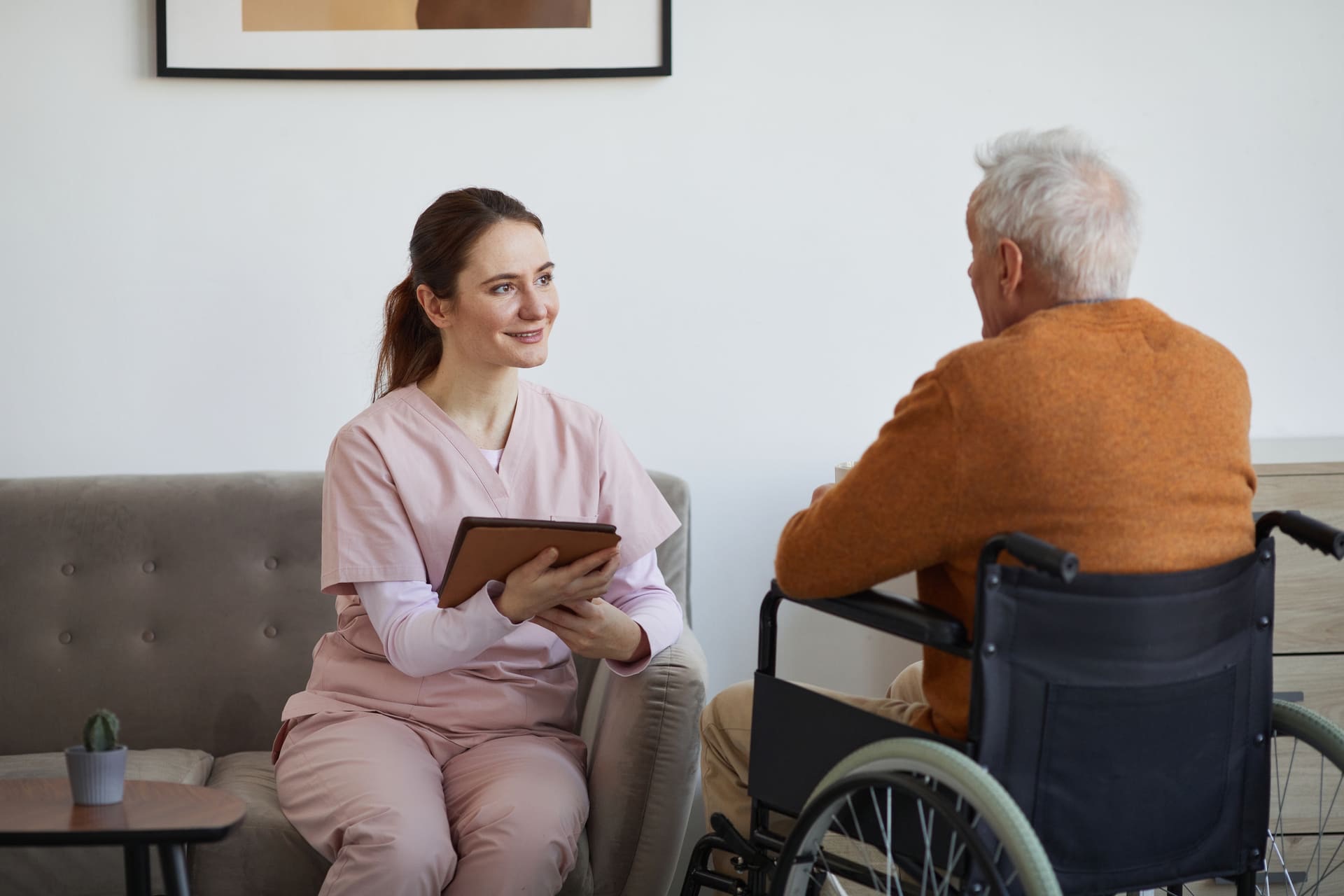 Alltagshelferin von Schöner Leben im persönlichen Beratungsgespräch mit einem älteren Mann